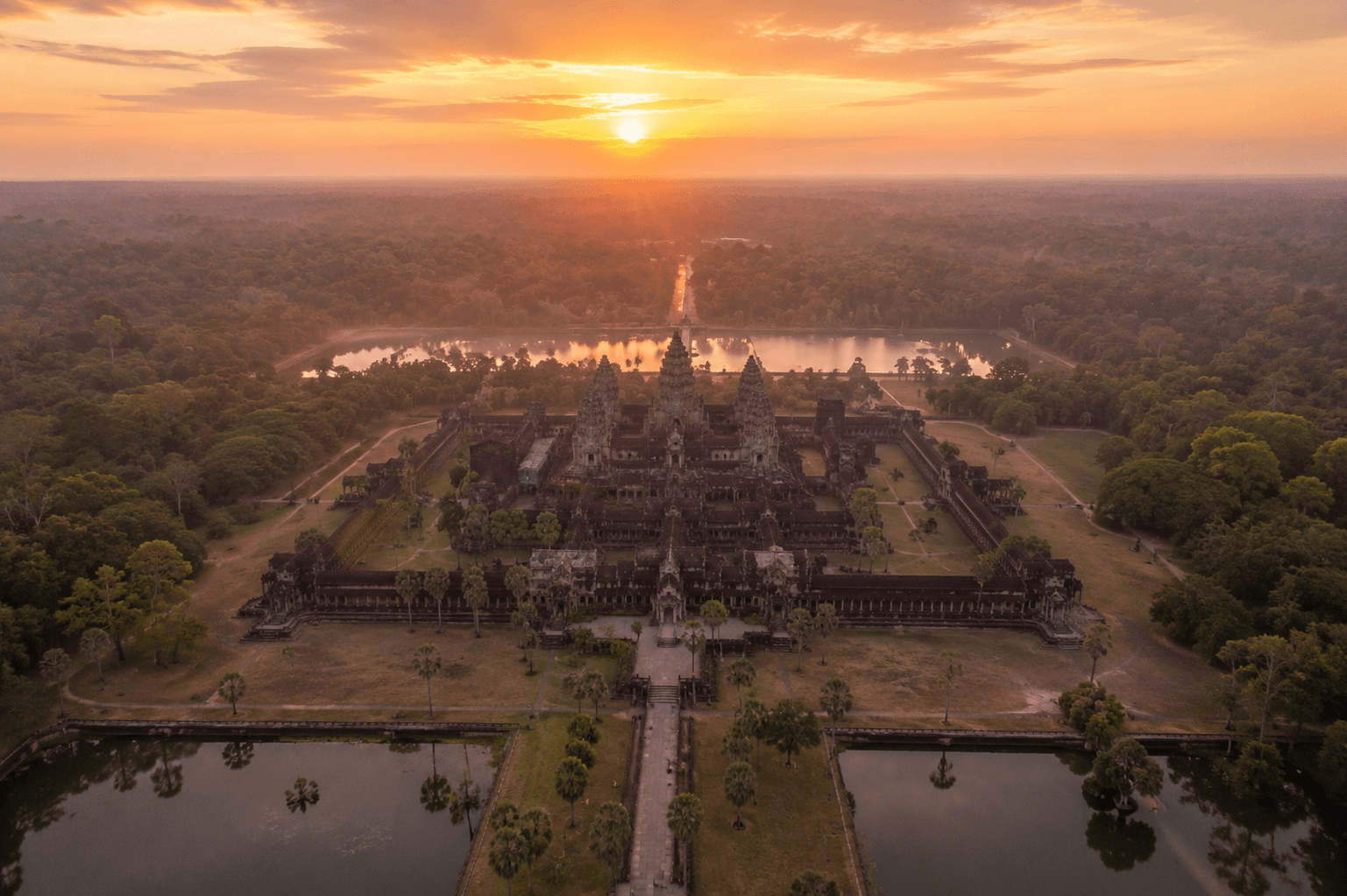 Vista aérea del complejo de Angkor Wat rodeado de selva al amanecer