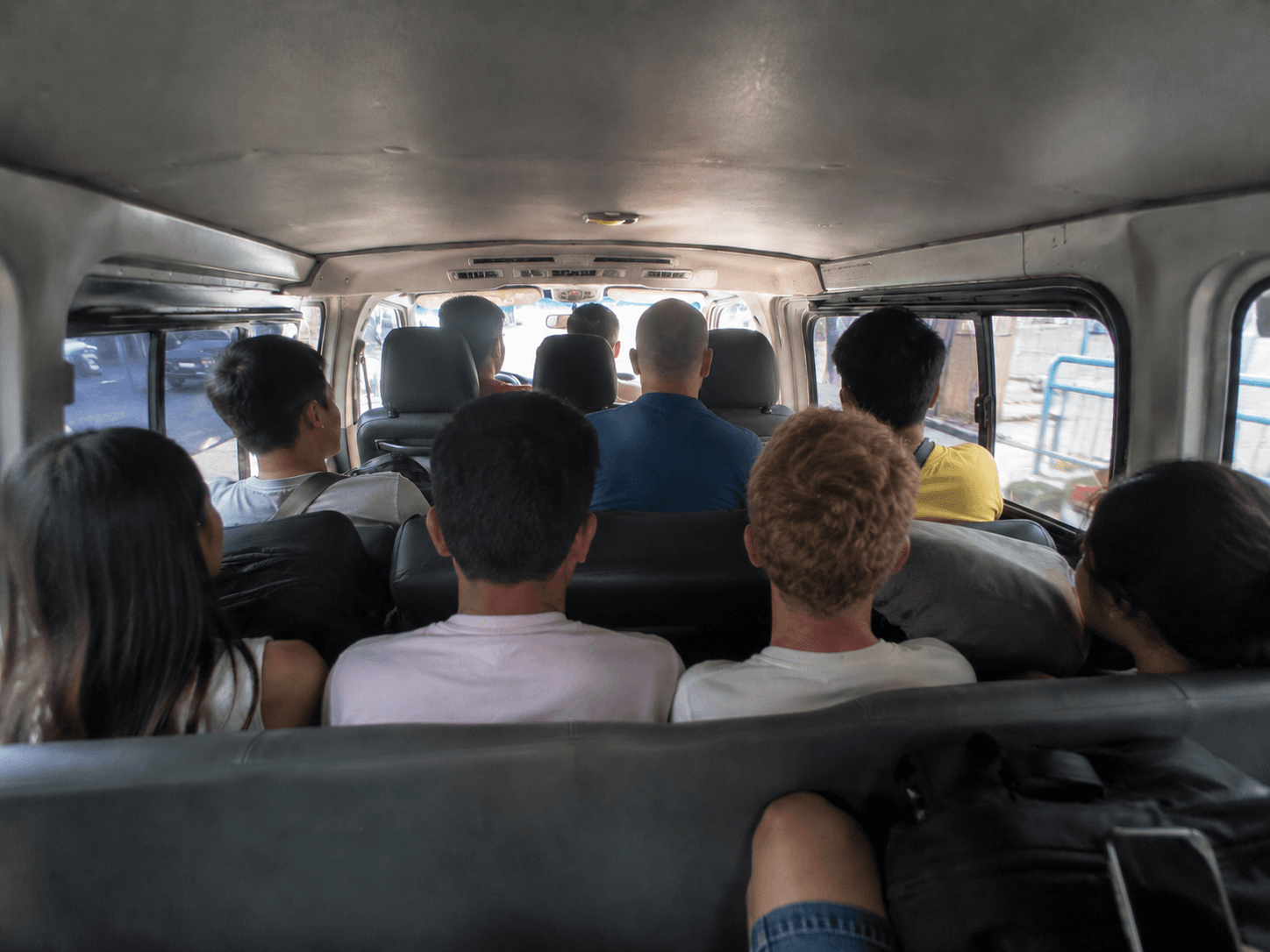 Interior de una van compartida de agencia en Filipinas abarrotada de pasajeros y equipaje