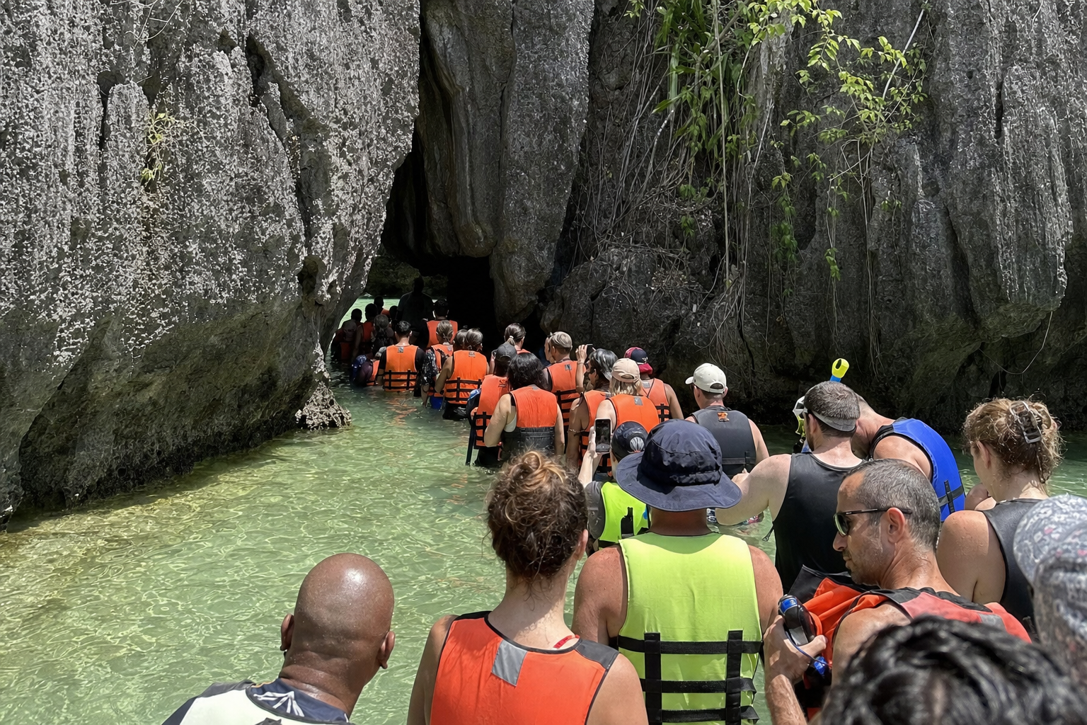 Turistas en fila esperando para entrar a una laguna en El Nido durante un tour en grupo.